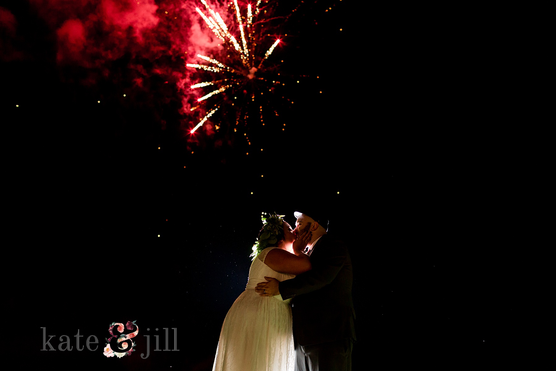 bride and groom kissing during fireworks