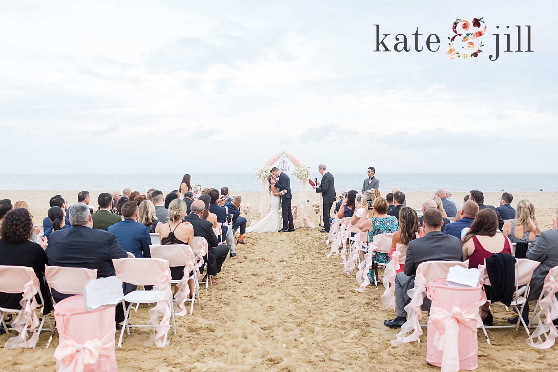 bride and groom first kiss on beach mcloone's pier house long branch