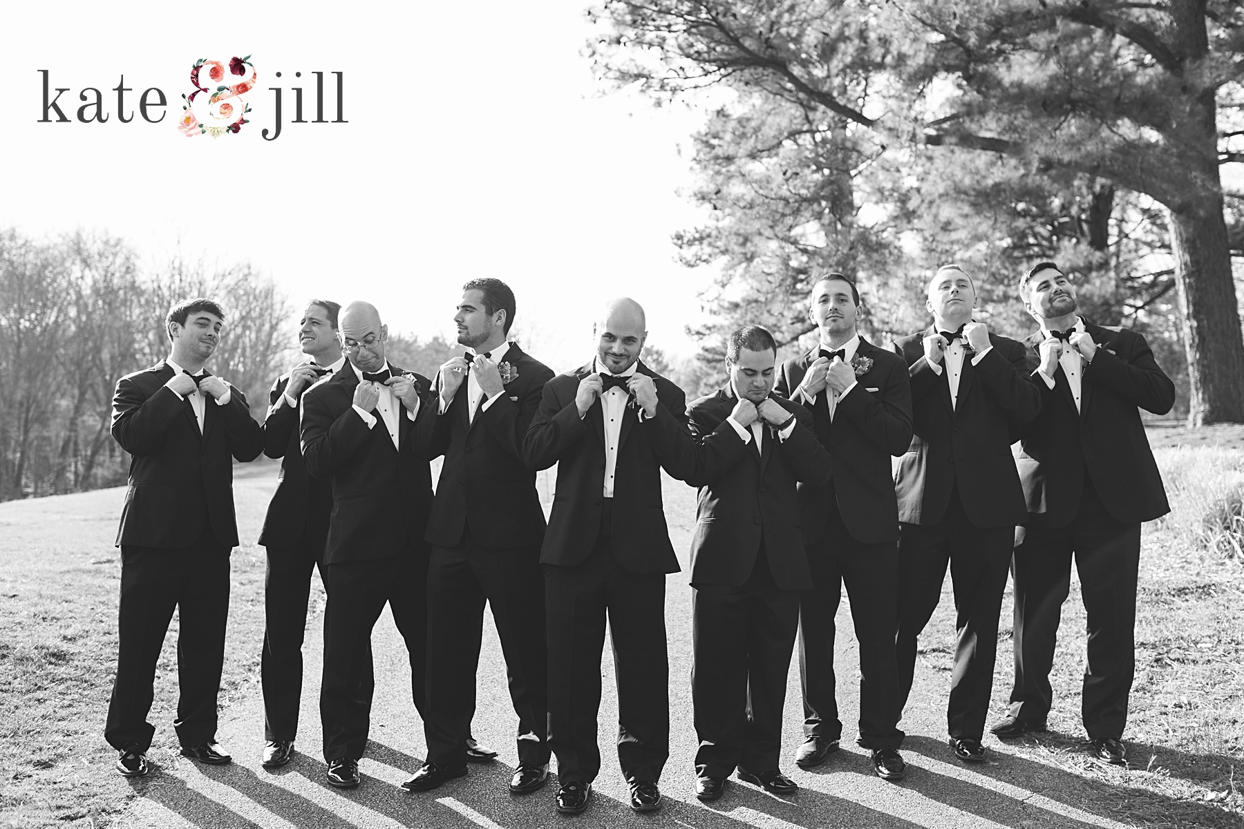groomsmen in black tuxes on golf course fixing ties woodcrest country club wedding