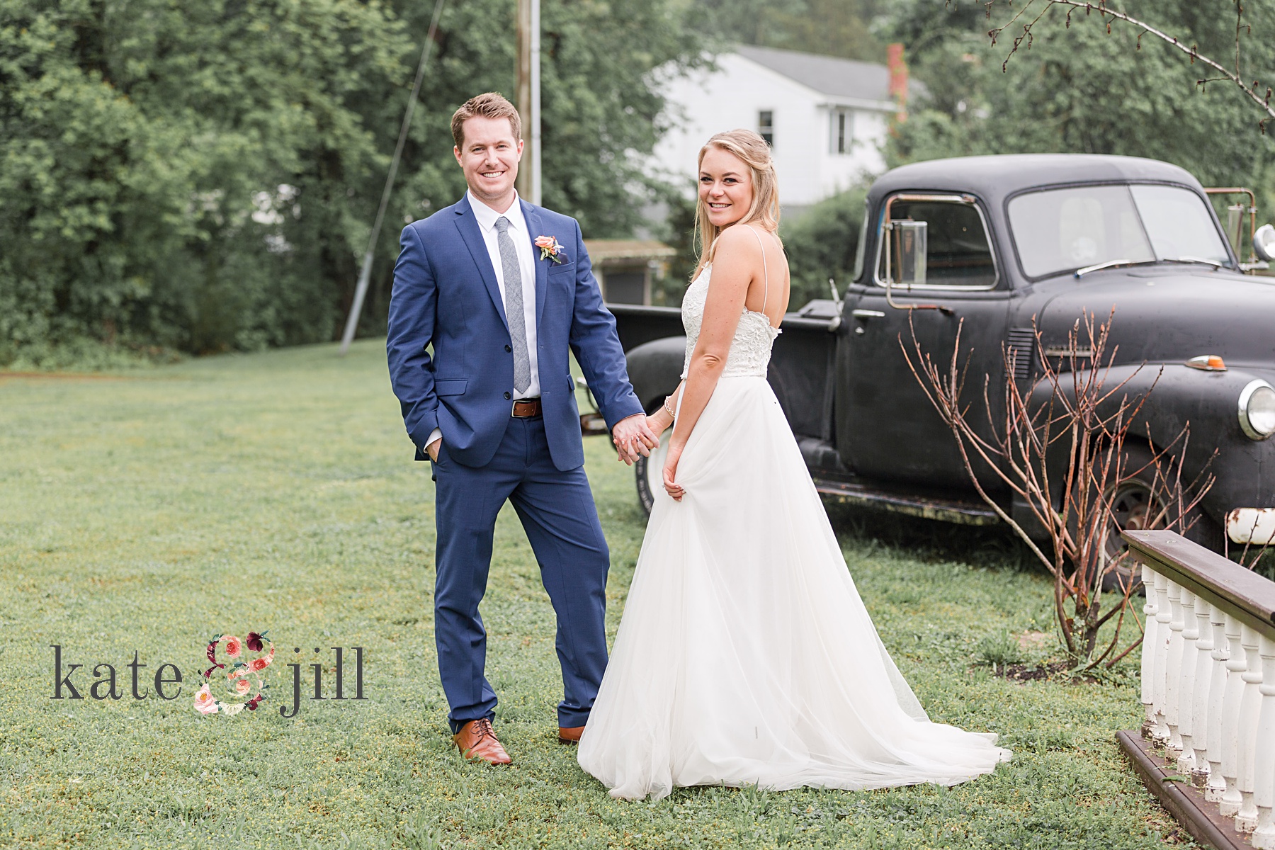 bride and groom standing in front of vintage truck holding hands
