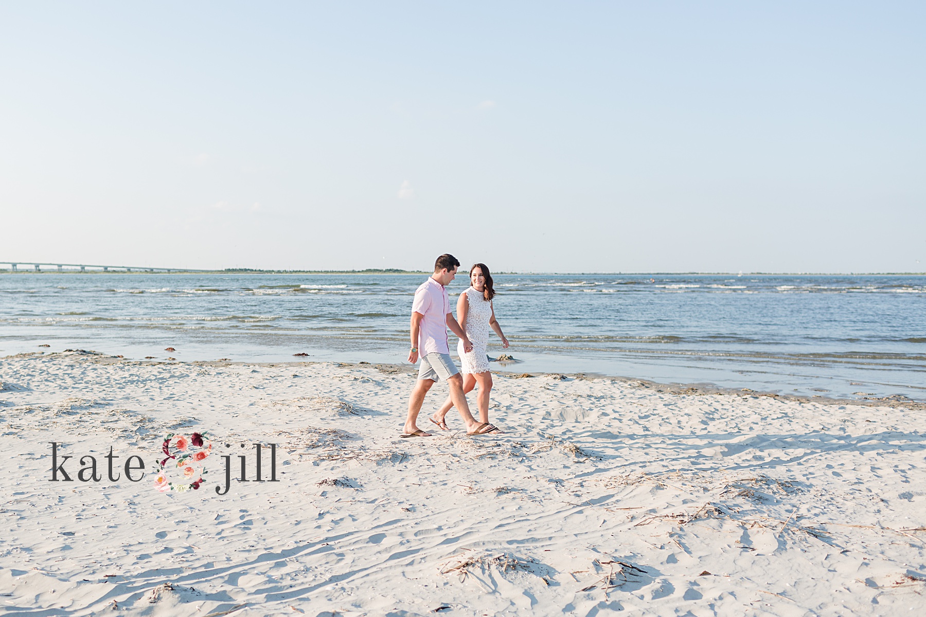 couple walking on beach while holding hands
