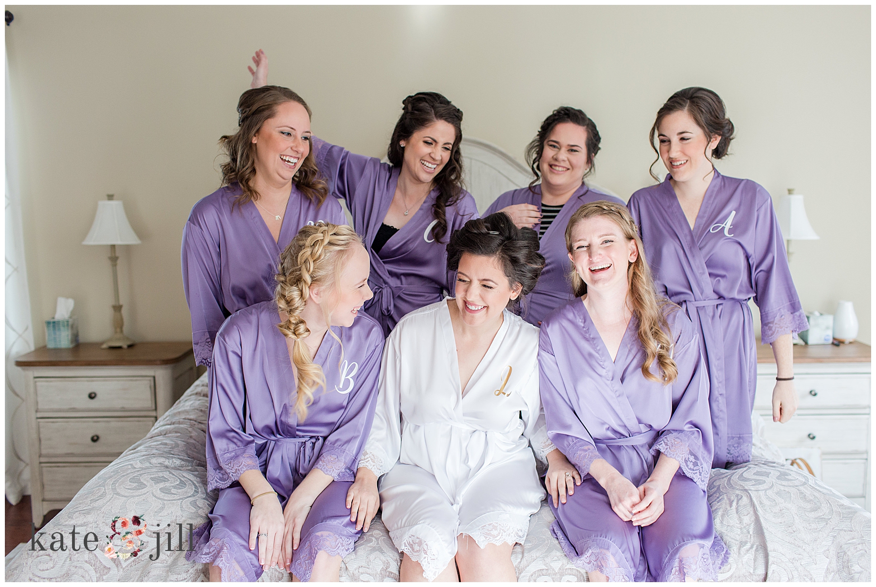 bridesmaids laughing on bed