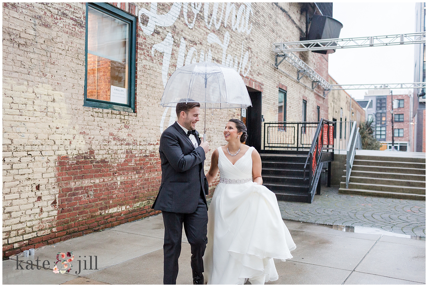 bride and groom walking with umbrella 