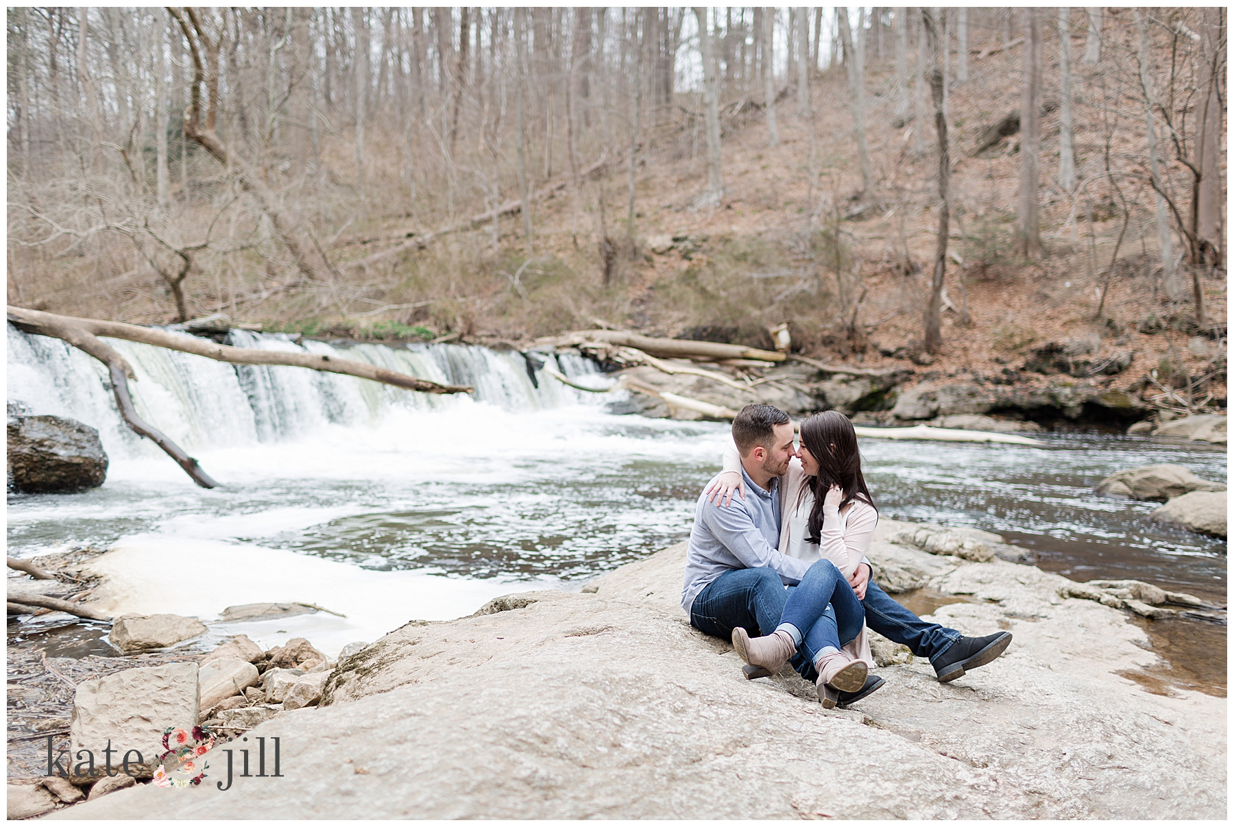 couple sitting in front of waterfall looking at each other philadelphia park