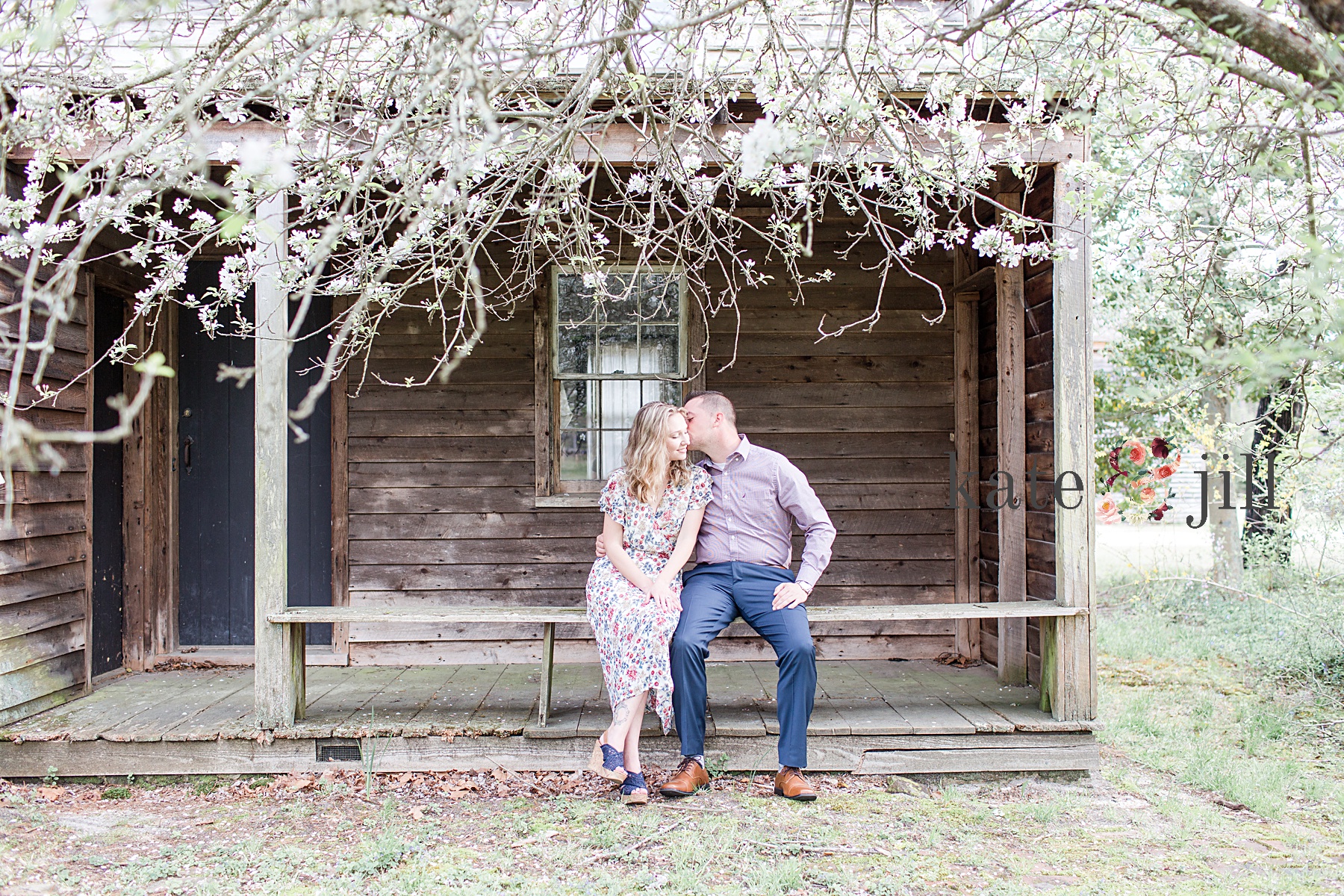 couple kissing in front of log cabin