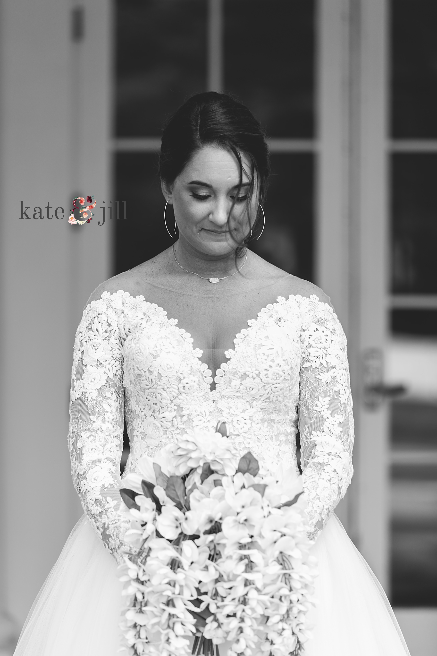 bride looking at flowers in black and white