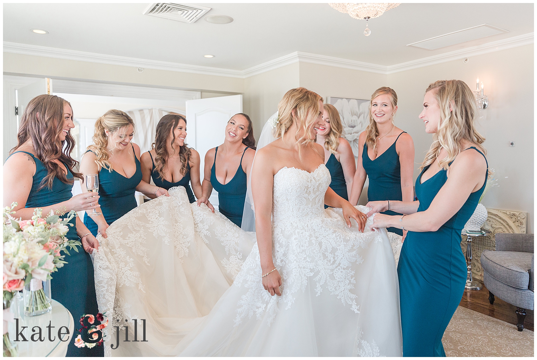 Bride with bridesmaids holding dress