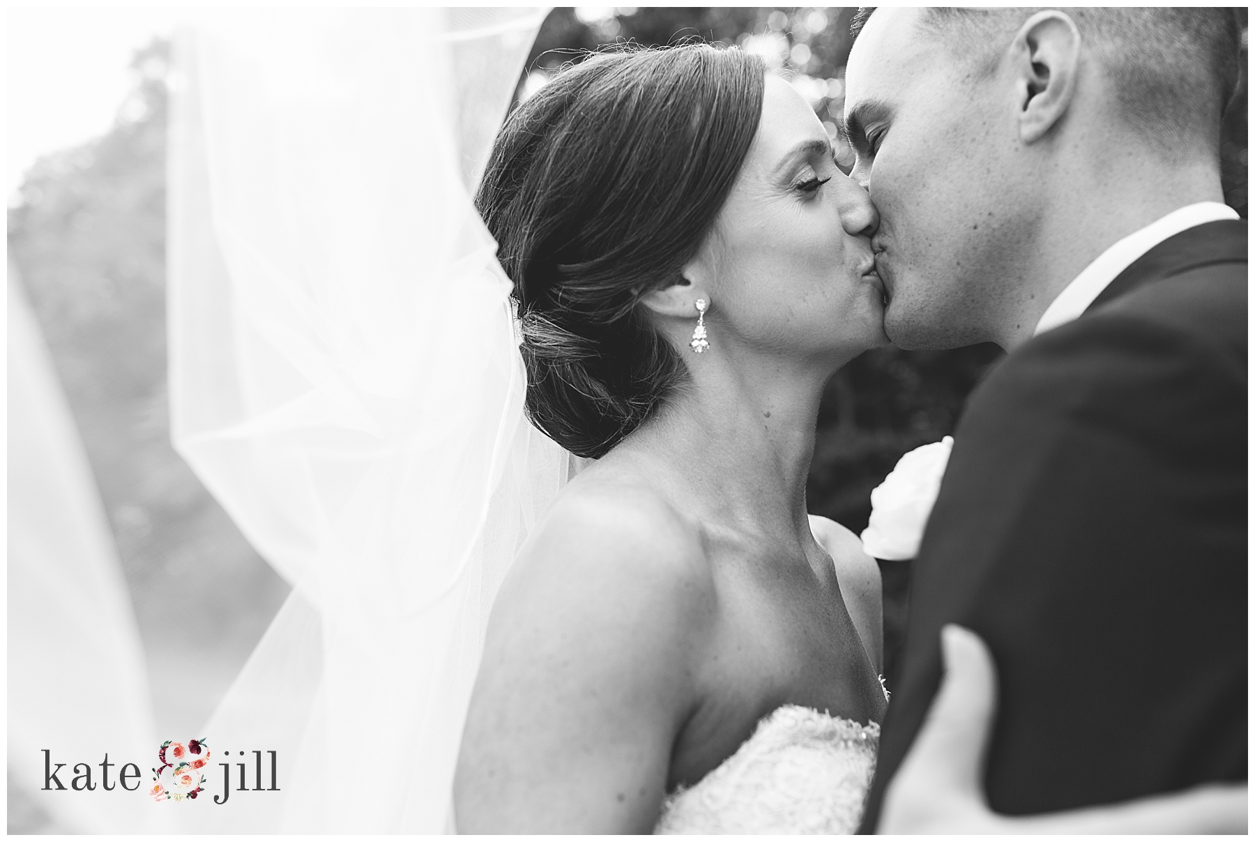 bride and groom kissing black and white